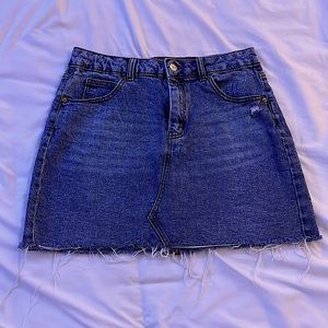 Blue jean skirt with decorative line down the middle.